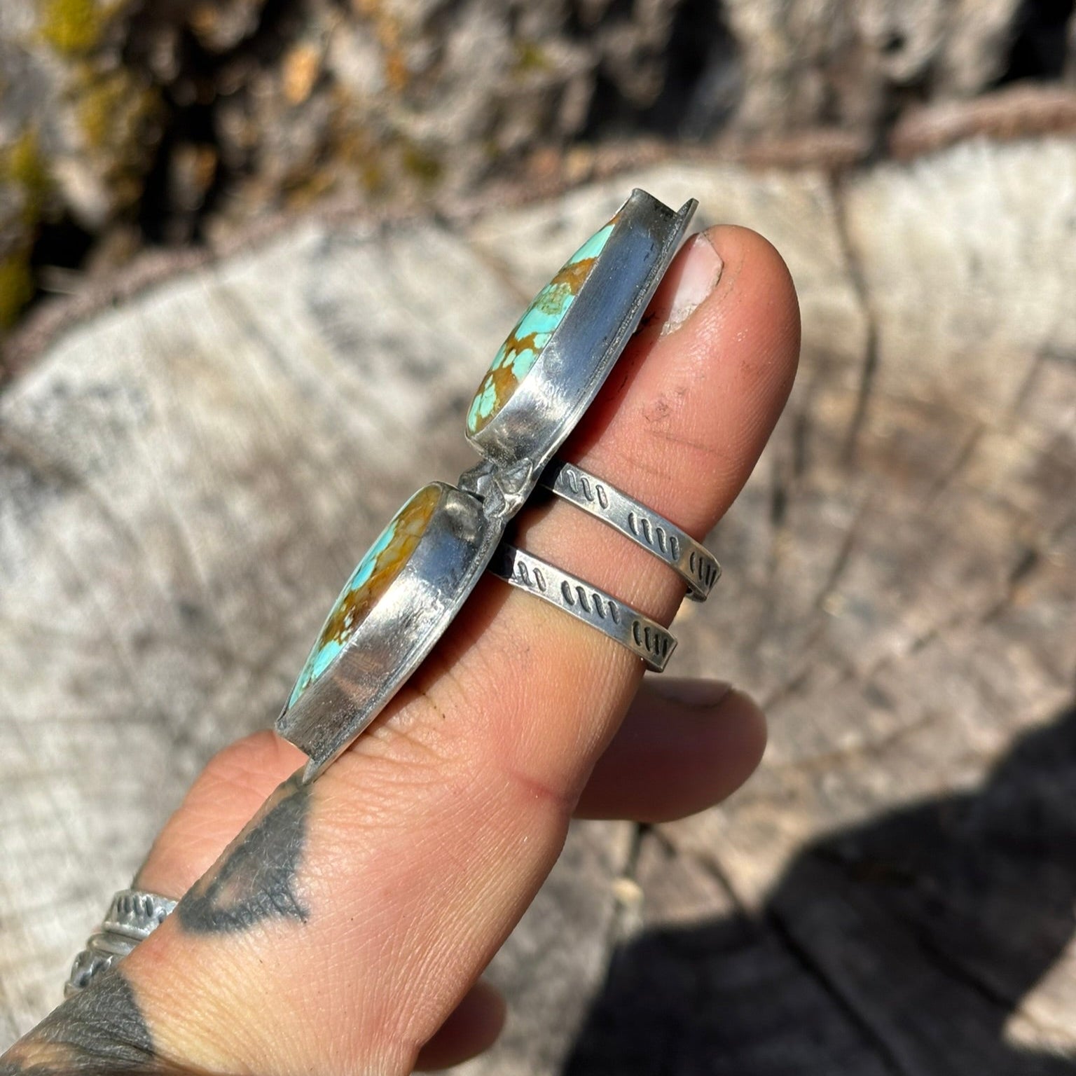 side view of turquoise and silver handmade ring showing the hand stamped double band