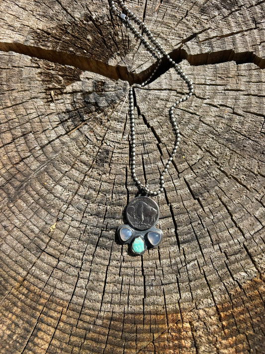 buffalo nickel and opalite and turquoise pendant on a silver ball chain on a cut wood round