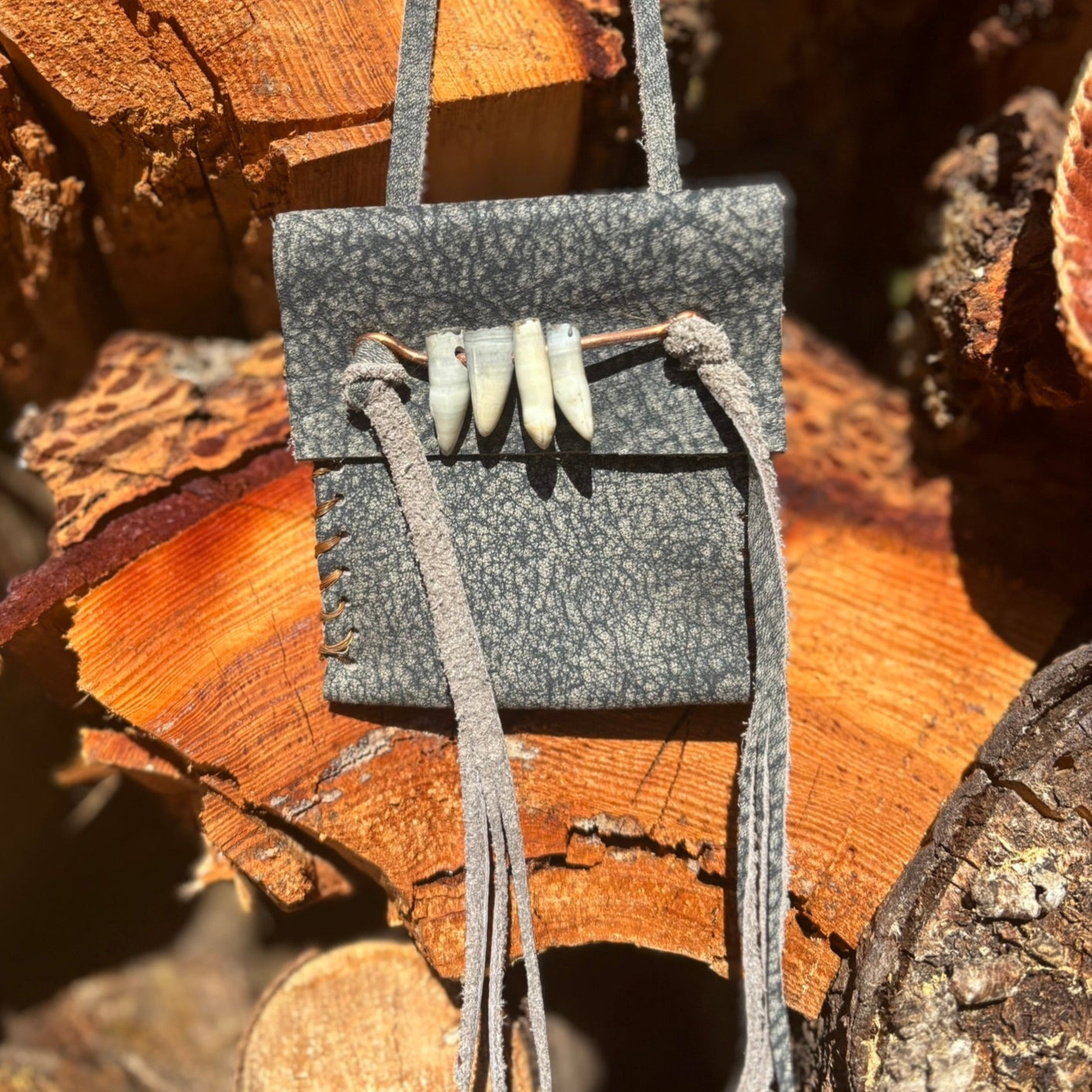 Small gray pouch with a strap on a wooden surface
