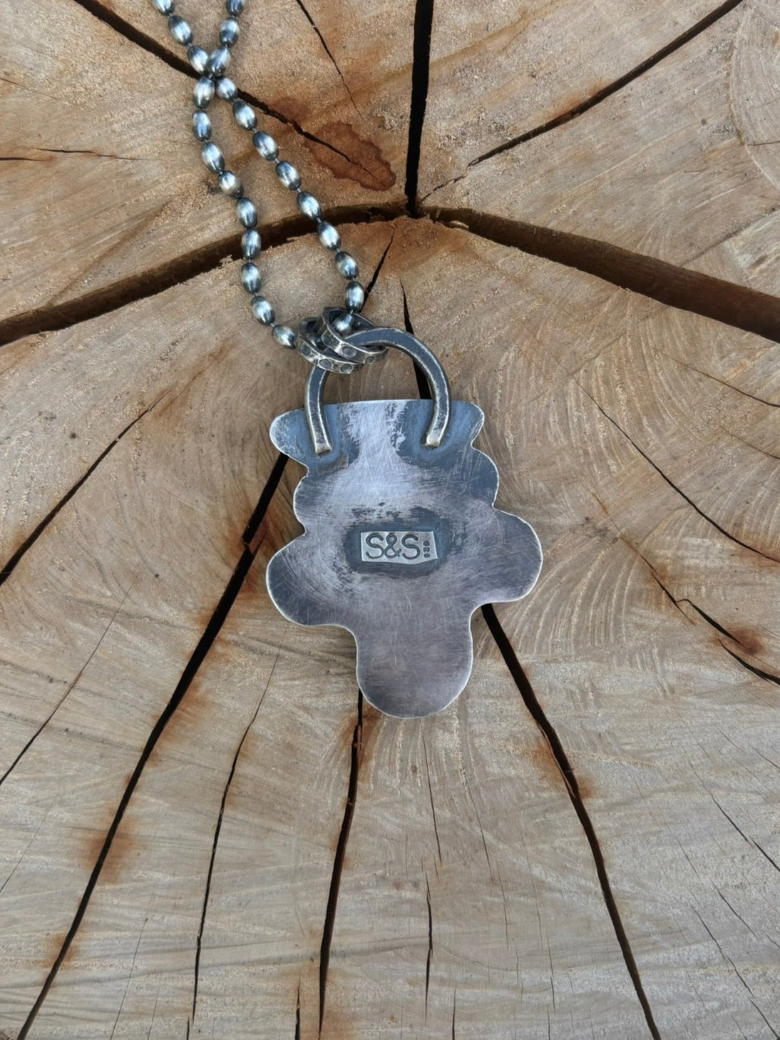 Silver necklace with a pendant on a wooden surface