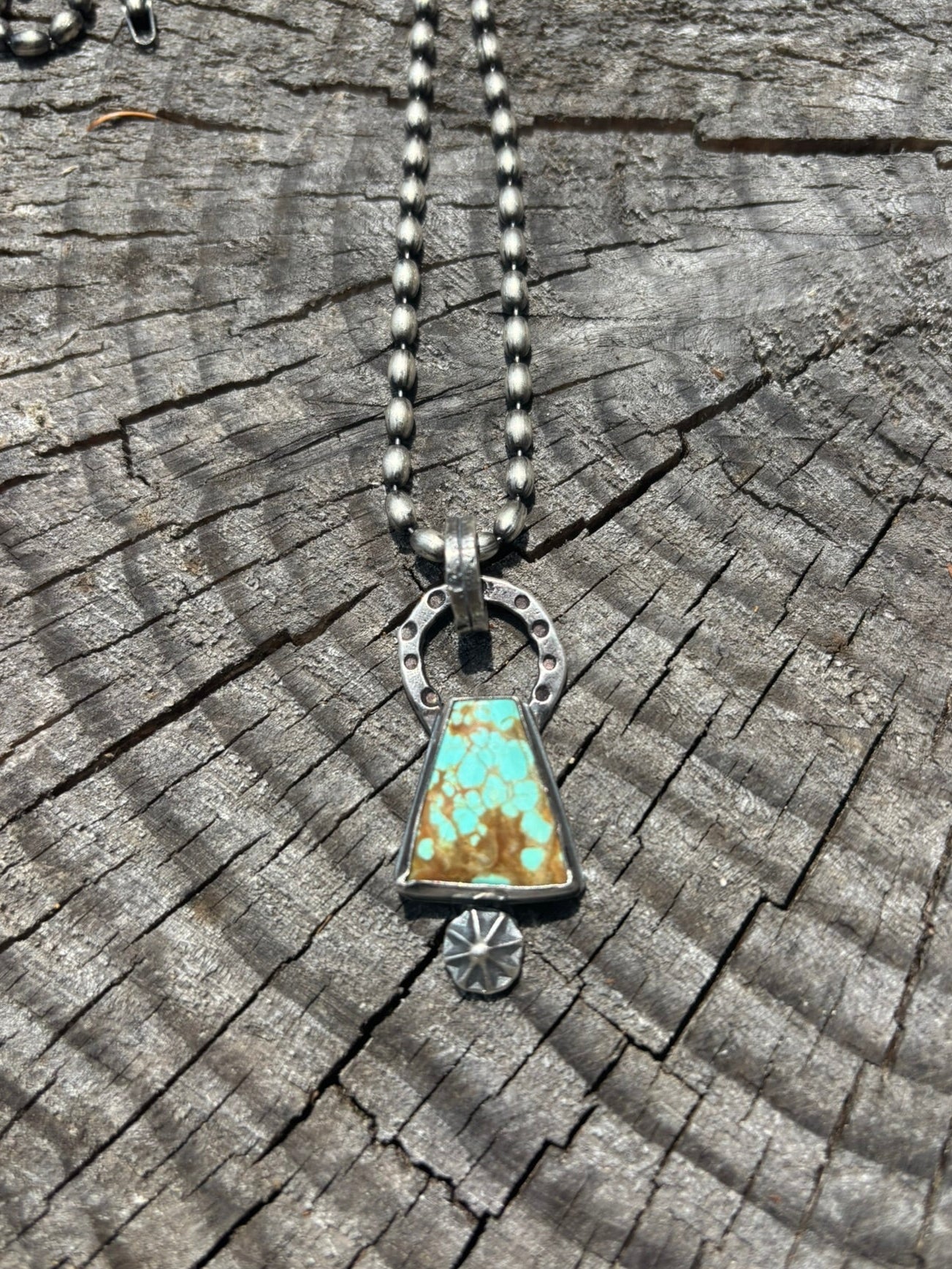 Necklace with a turquoise pendant on a wooden surface