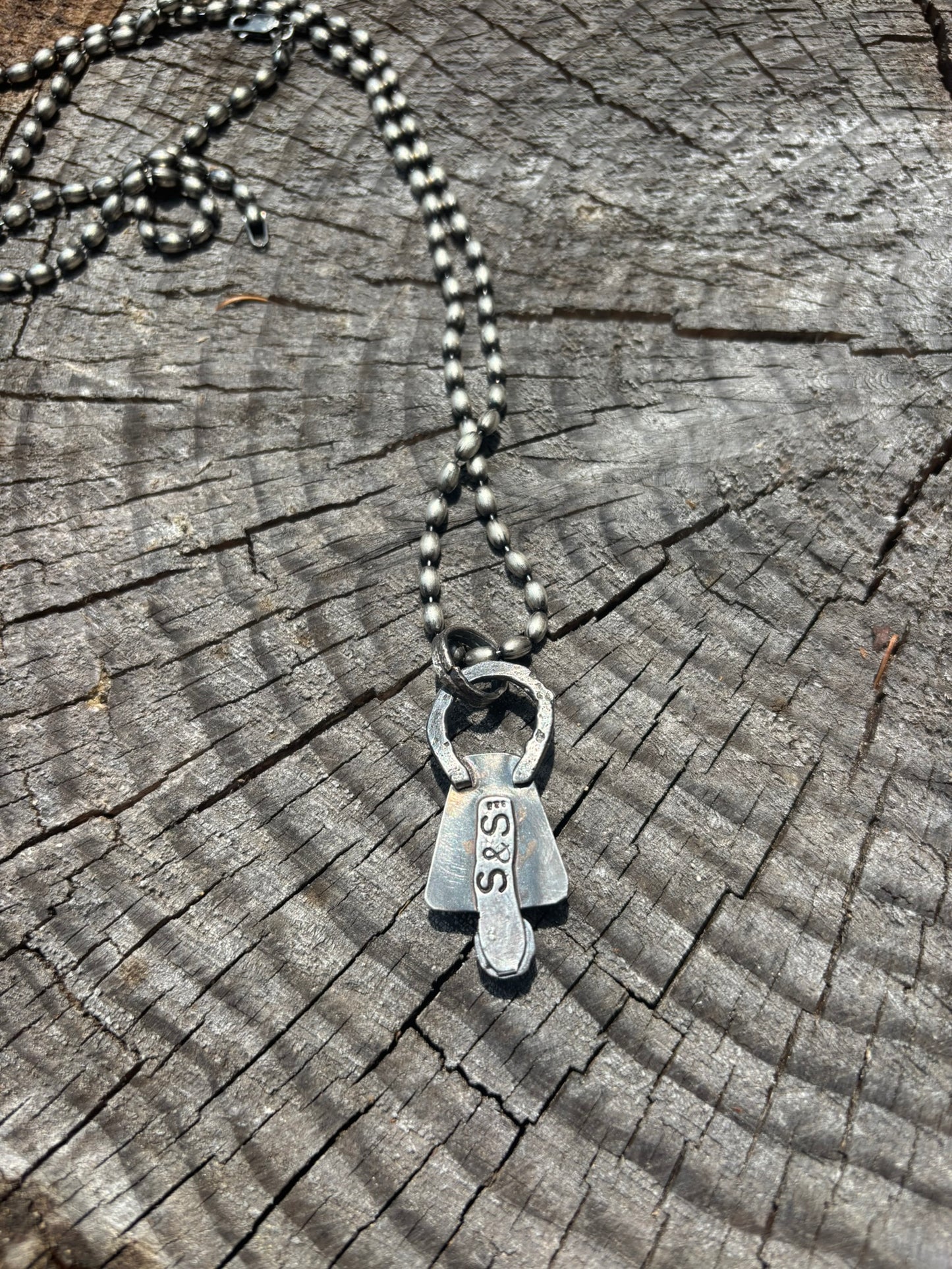Silver necklace with a pendant on a wooden surface