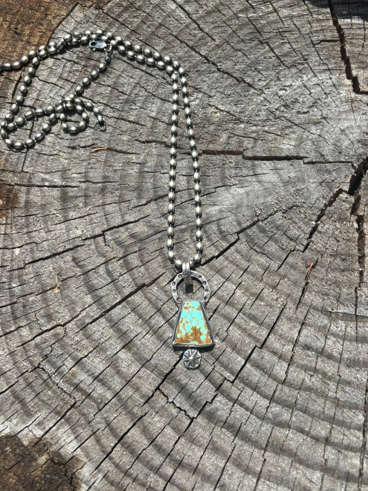 Necklace with a turquoise pendant on a wooden surface