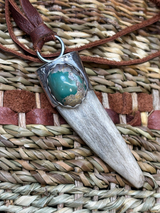 antler tip pendant with handmade silver cap, hand stamped details and a turquoise stone, on a leather strap.