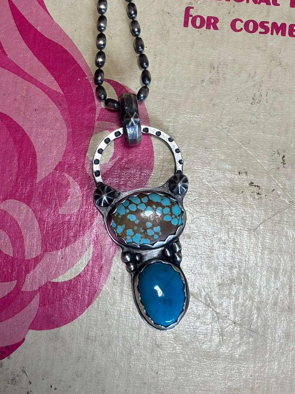 Necklace with a blue pendant on a cosmetology textbook