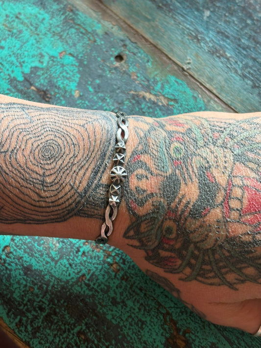 silver cuff with twisted hammered band and 5 silver star shots on tattooed hand/wrist