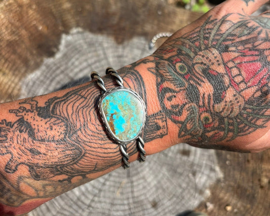 handmade turquoise and silver cuff with twisted wire, double band, large quality stone and stamped details worn on tattooed wrist 