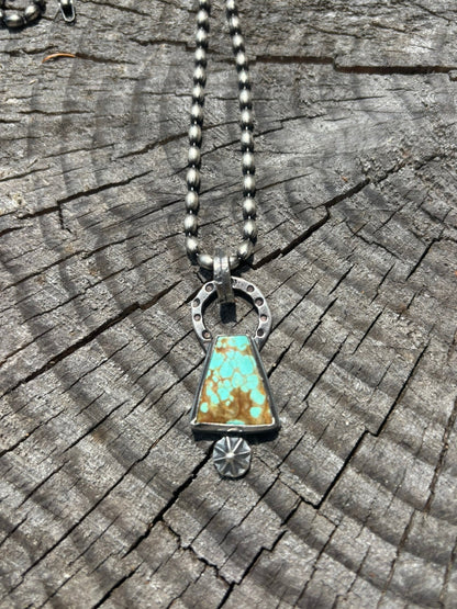 Necklace with a turquoise pendant on a wooden surface