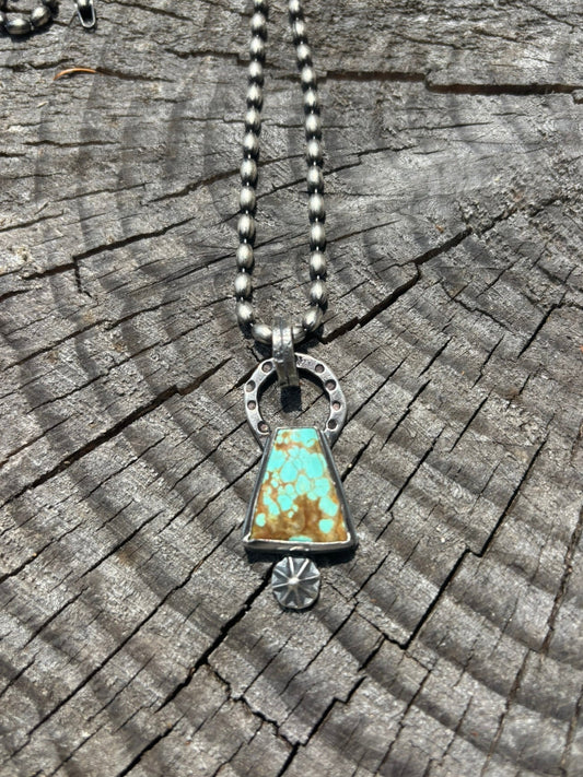 Necklace with a turquoise pendant on a wooden surface
