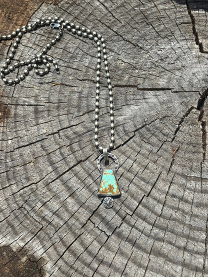 Necklace with a turquoise pendant on a wooden surface
