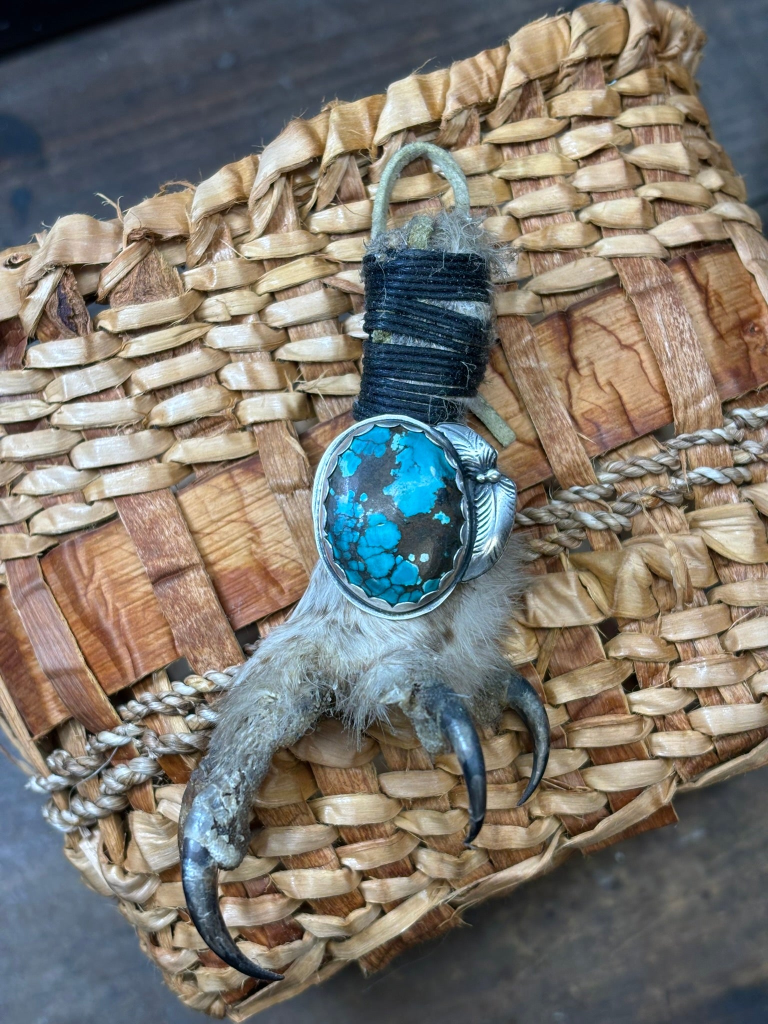 handmade turquoise and feathers ring. sterling and fine silver. shown on an owl claw on handmade cedar basket