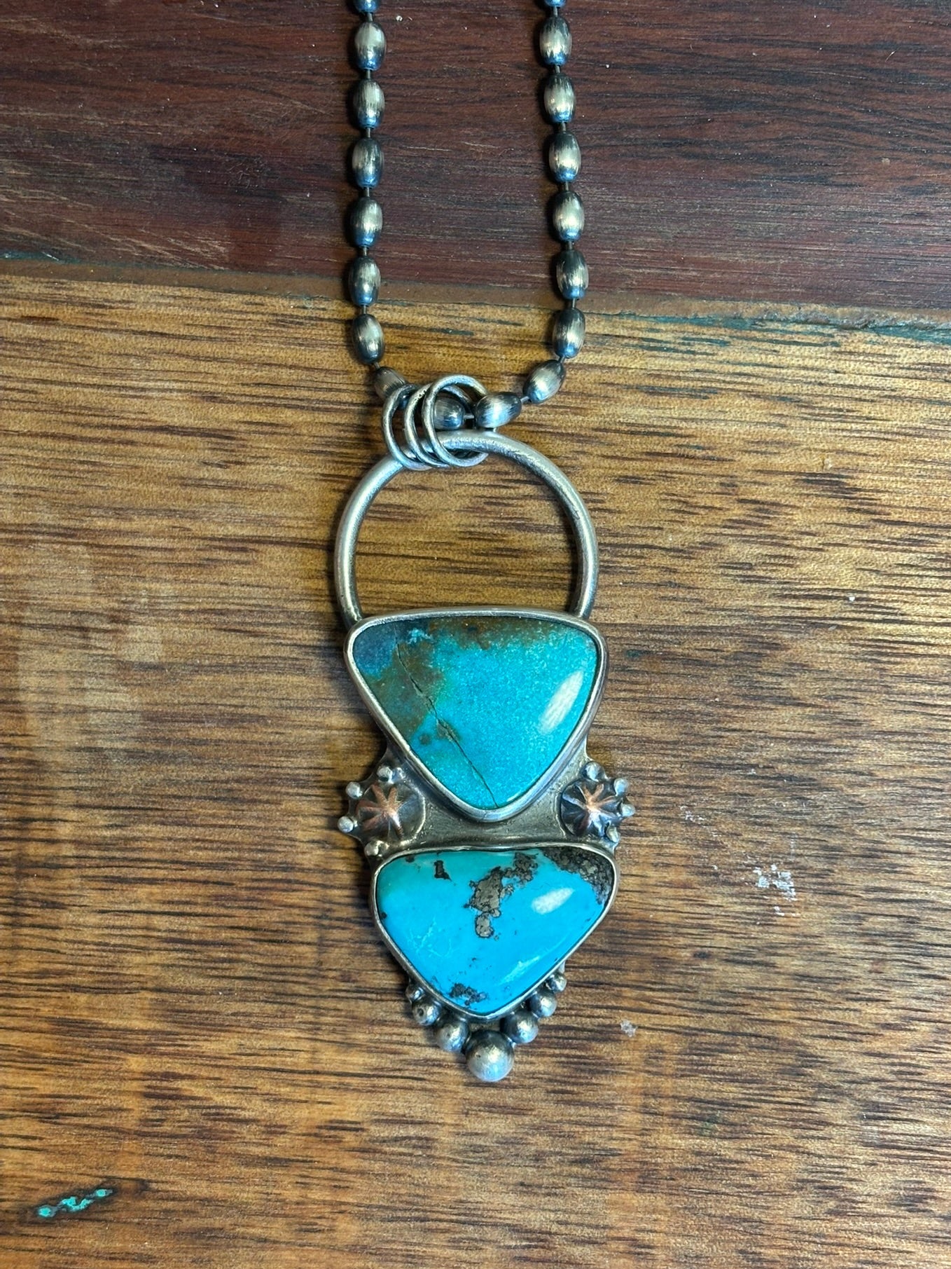 Turquoise pendant necklace on a wooden surface